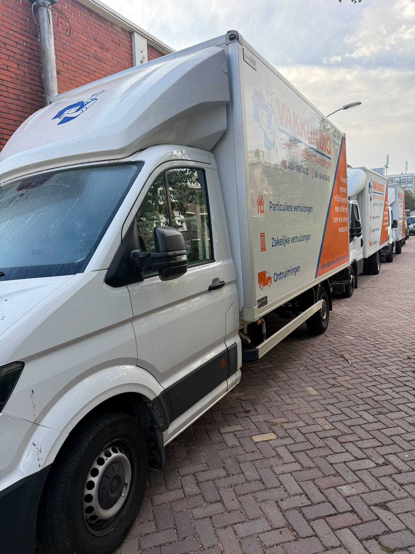 Wagenpark van Vakkundig Verhuizingen & Transport met bakwagens op rij